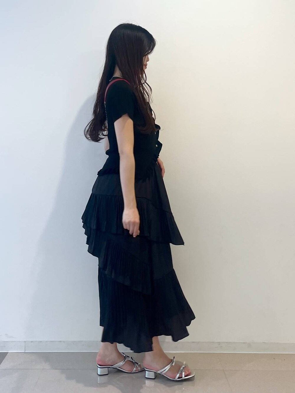 ホワイト系のキャミソール、ブラック系のスカート、シルバー系のサンダルを着用したレディースの春コーディネートの5枚目の写真