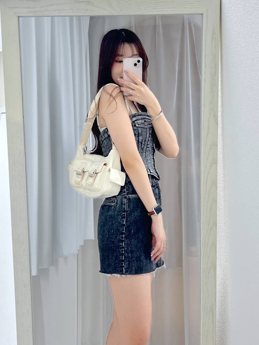 ホワイト系のショルダーバッグ、ブルー系のその他トップス、ブラック系のデニムスカートを着用したレディースの春コーディネートの2枚目の写真