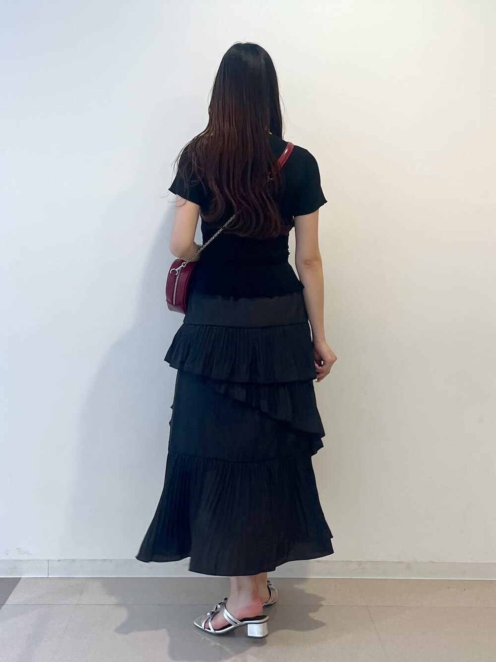 ホワイト系のキャミソール、ブラック系のスカート、シルバー系のサンダルを着用したレディースの春コーディネートの4枚目の写真