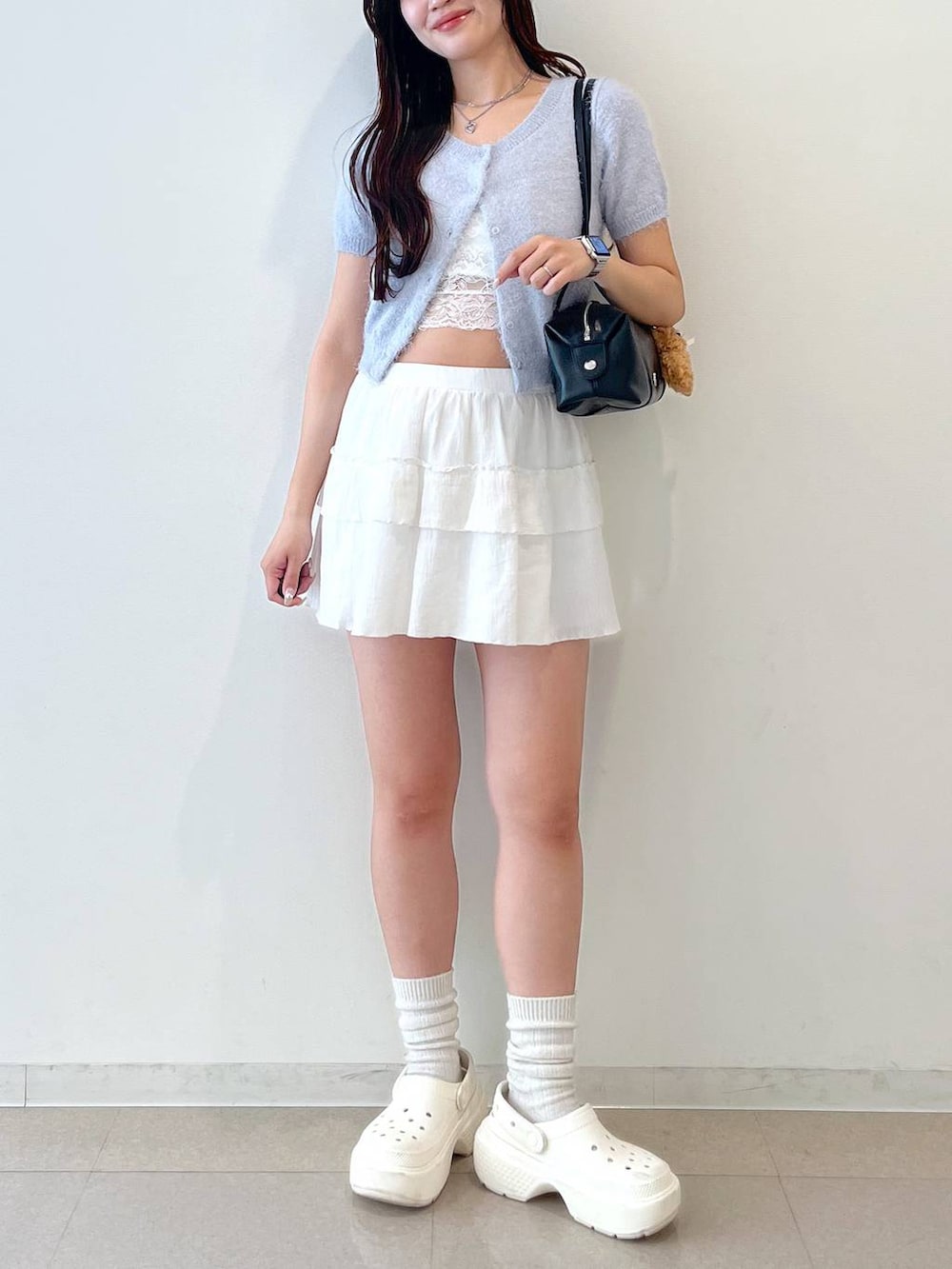ホワイト系のスカート、ブラック系のボストンバッグ、ホワイト系のキャミソールを着用したレディースの春コーディネートの9枚目の写真