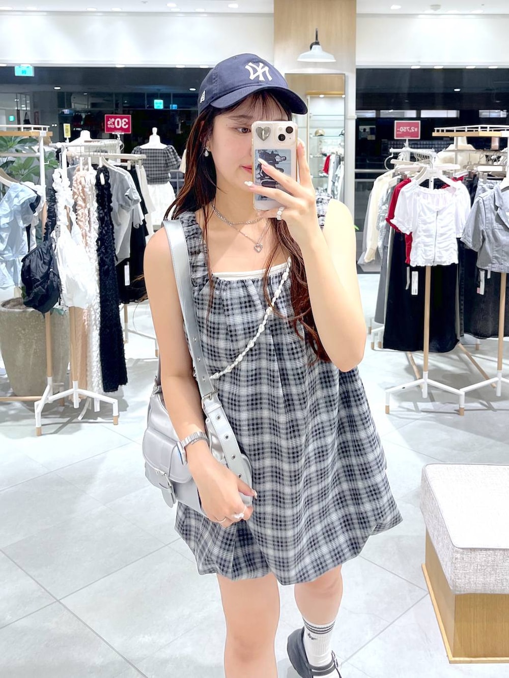 ブラック系のスニーカー、ホワイト系のキャミソール、シルバー系のショルダーバッグを着用したレディースの夏コーディネートの3枚目の写真