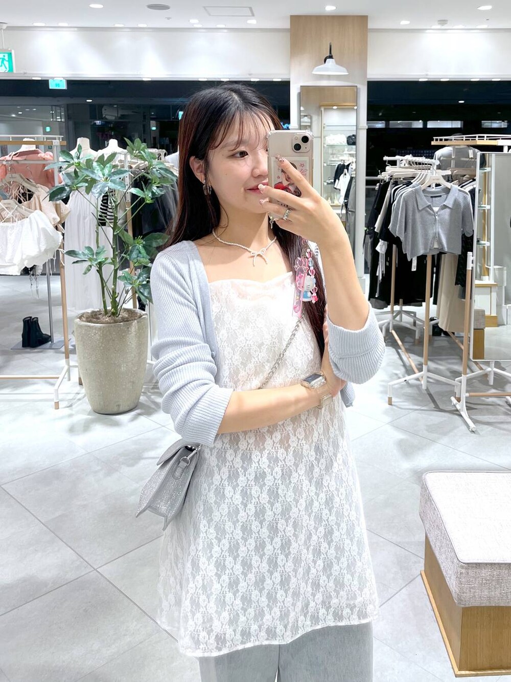 シルバー系のサンダル、ブルー系のカーディガン/ボレロ、ホワイト系のキャミソールを着用したレディースの夏コーディネートの2枚目の写真