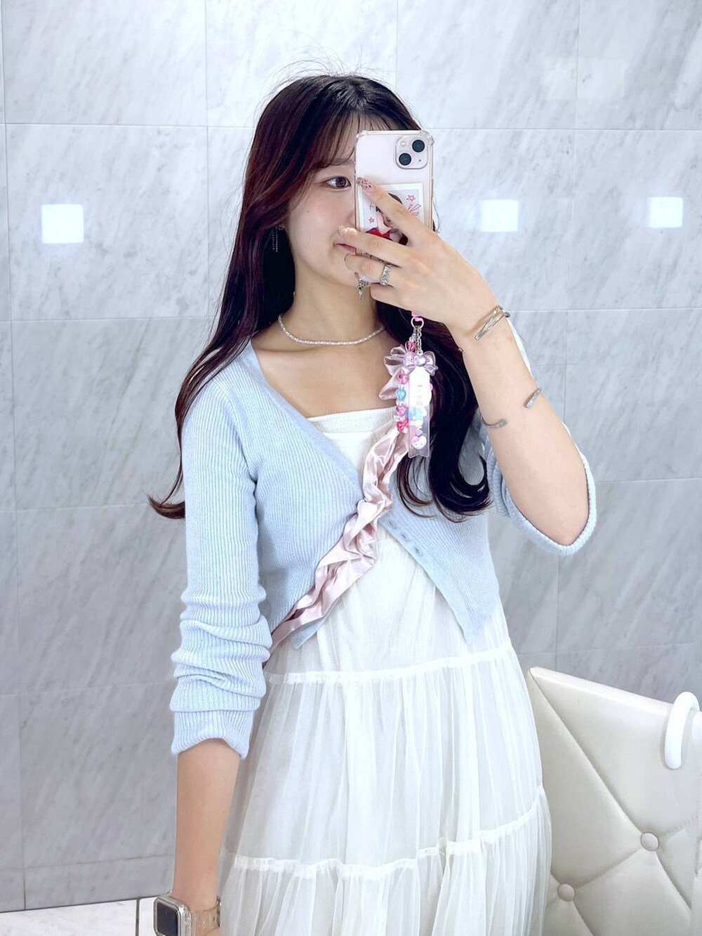 ピンク系のショルダーバッグ、ホワイト系のキャミソール、ブルー系のデニムパンツを着用したレディースの夏コーディネートの4枚目の写真