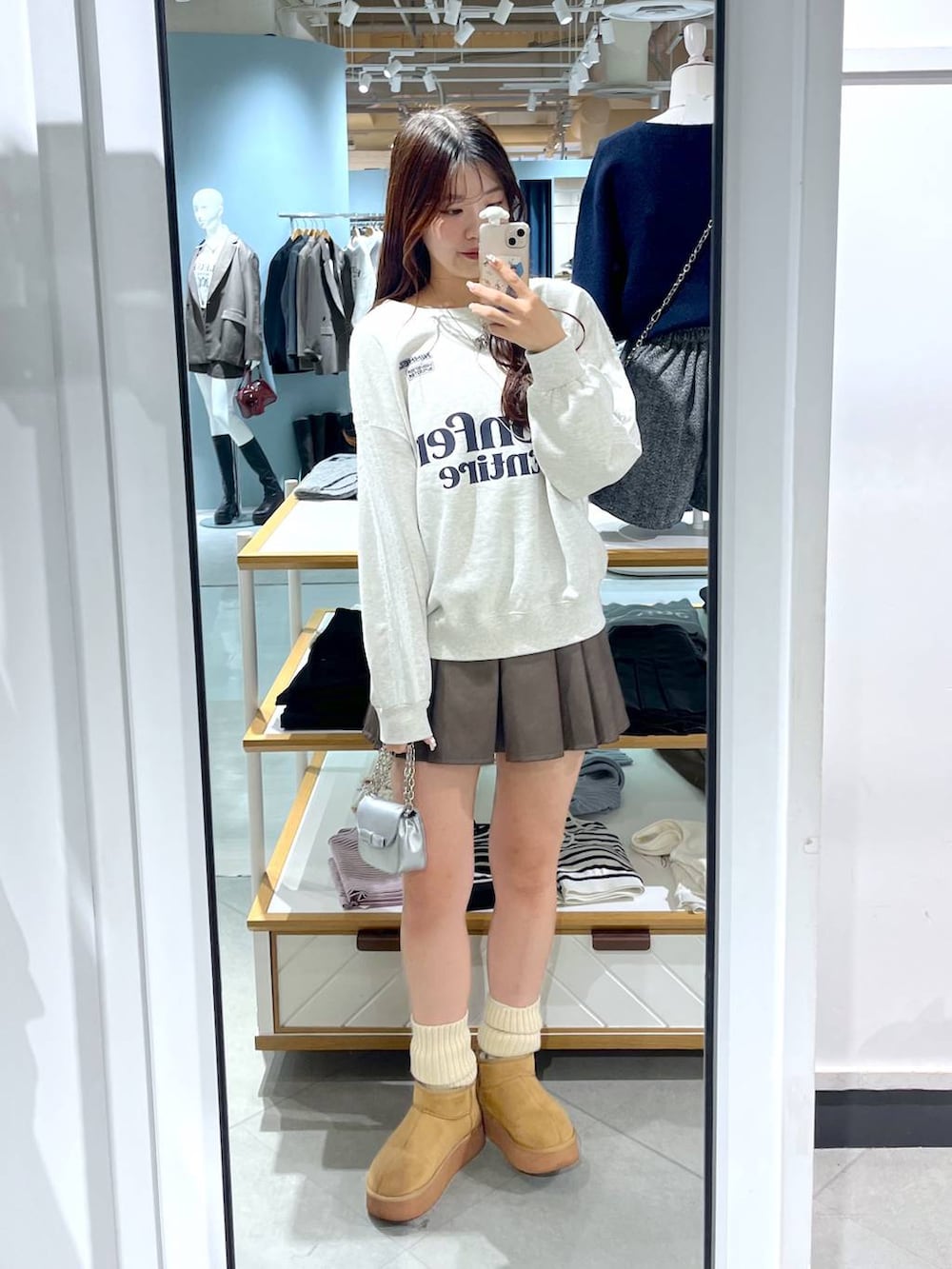 ホワイト系のTシャツ/カットソー、ブラウン系のスカート、ベージュ系のブーツを着用したレディースの冬コーディネートの7枚目の写真