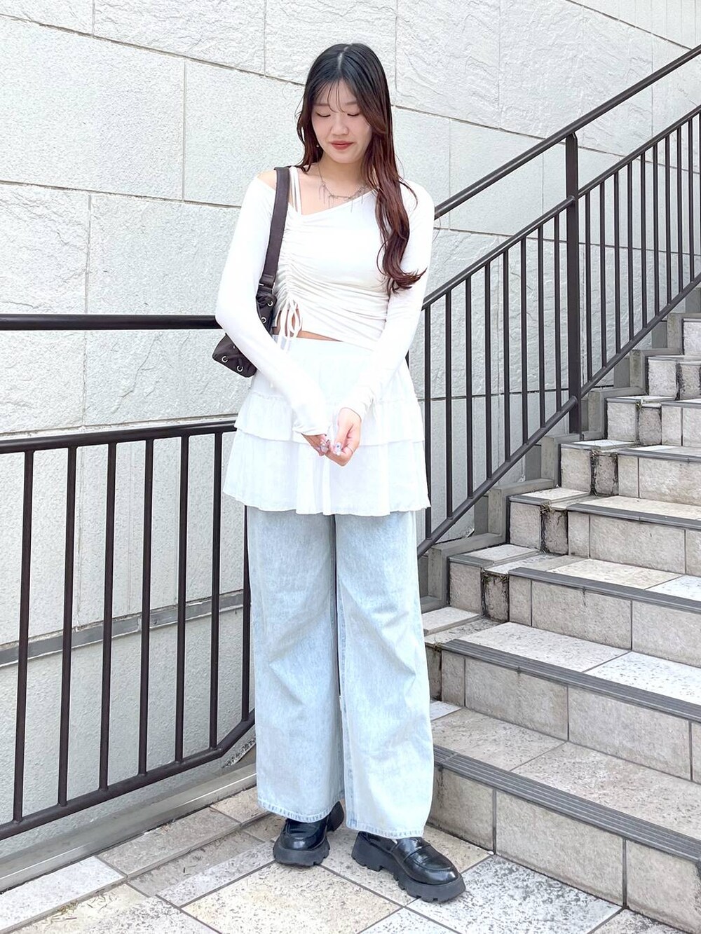 ホワイト系のキャミソール、ブルー系のデニムパンツ、ホワイト系のスカートを着用したレディースの春コーディネートの2枚目の写真