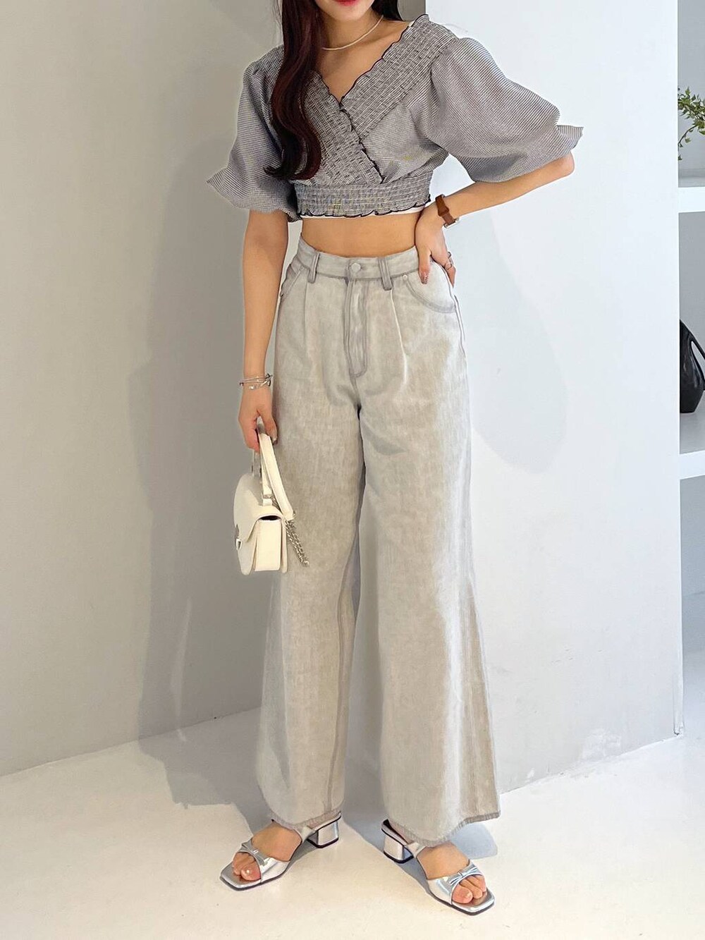 シルバー系のサンダル、ホワイト系のキャミソール、グレー系のデニムパンツを着用したレディースの春コーディネートの7枚目の写真