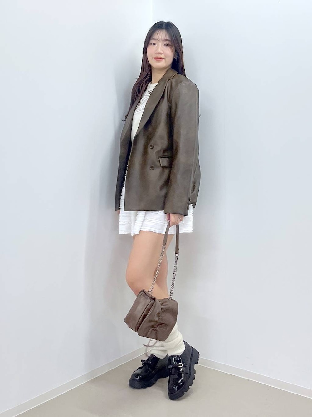 ホワイト系のキャミソール、ブラック系のドレスシューズ、ブラウン系のテーラードジャケットを着用したレディースの春コーディネートの5枚目の写真