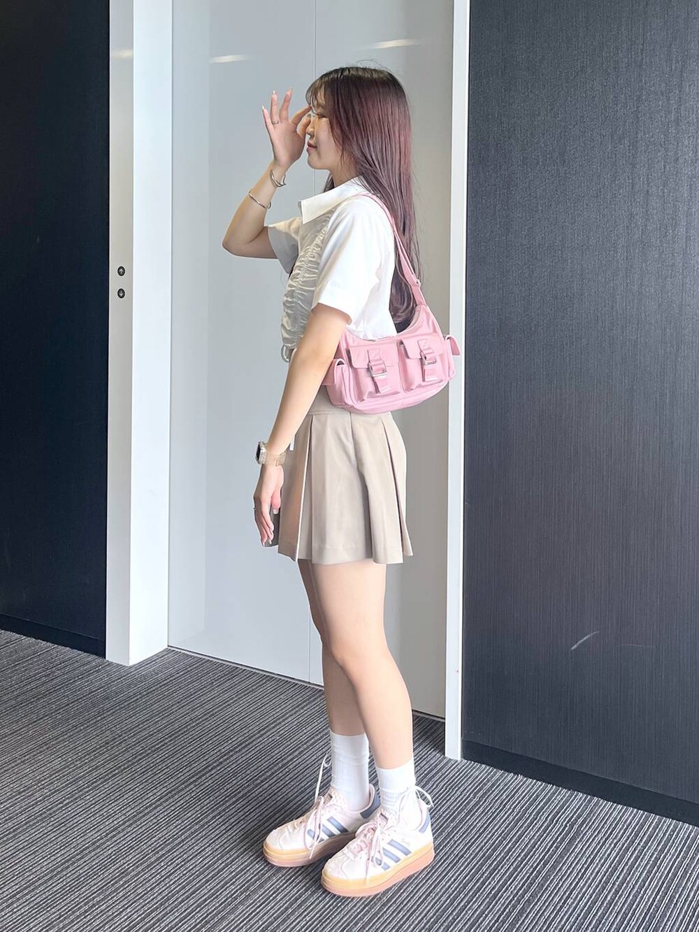 ピンク系のショルダーバッグ、ホワイト系のキャミソール、ベージュ系のスカートを着用したレディースの夏コーディネートの7枚目の写真