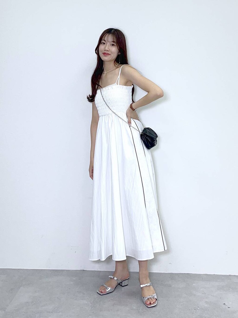 ブラック系のショルダーバッグ、ホワイト系のキャミソール、シルバー系のサンダルを着用したレディースの春コーディネートの2枚目の写真