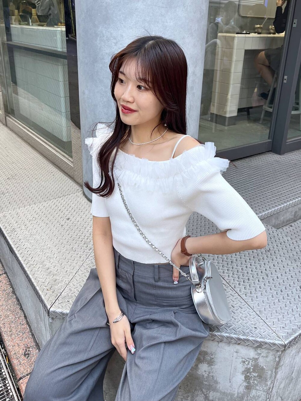 シルバー系のショルダーバッグ、ブラック系のローファー、グレー系のスラックスを着用したレディースの春コーディネートの3枚目の写真