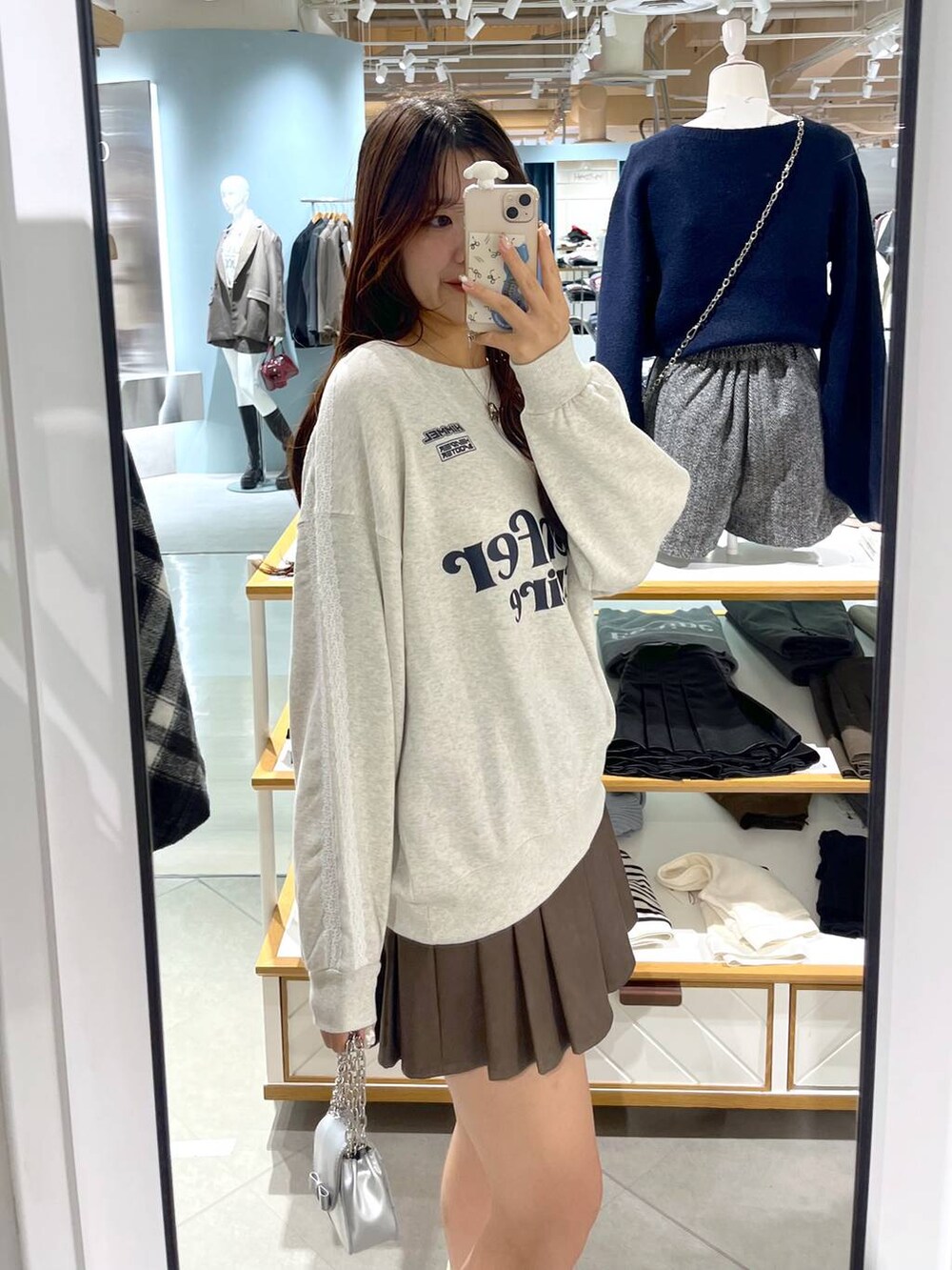 ホワイト系のTシャツ/カットソー、ブラウン系のスカート、ベージュ系のブーツを着用したレディースの冬コーディネートの8枚目の写真