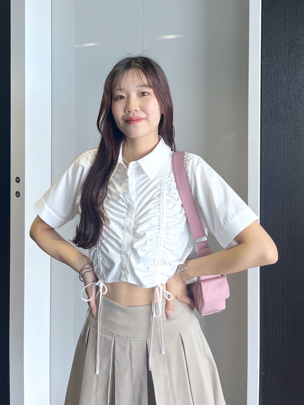 ピンク系のショルダーバッグ、ホワイト系のキャミソール、ベージュ系のスカートを着用したレディースの夏コーディネートの4枚目の写真