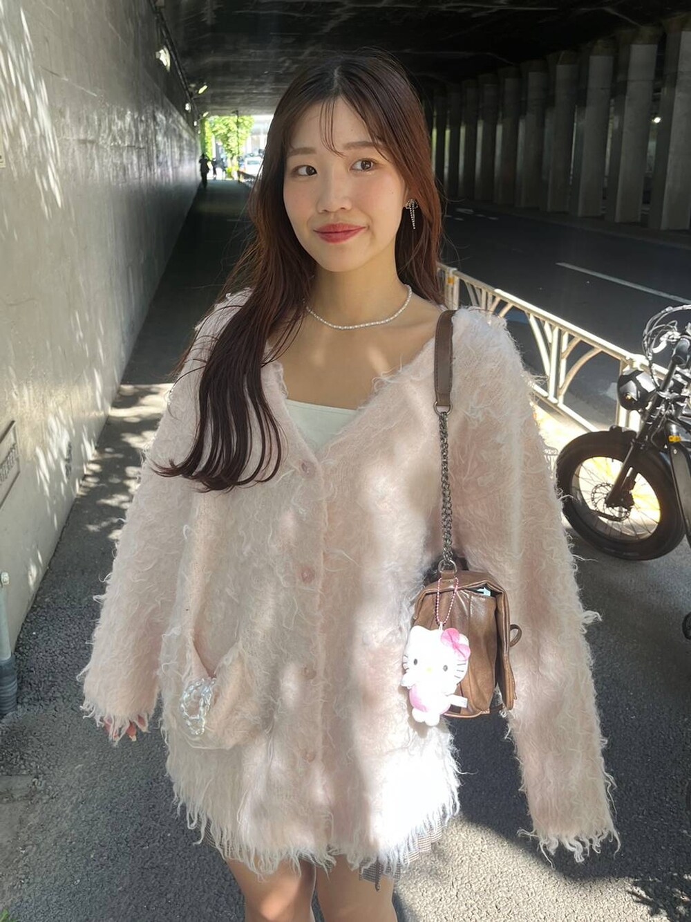 ブラウン系のショルダーバッグ、ブラウン系のブーツ、ホワイト系のキャミソールを着用したレディースの秋コーディネートの4枚目の写真