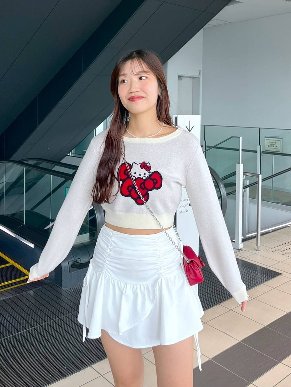 ホワイト系のTシャツ/カットソー、レッド系のショルダーバッグ、ブラック系のブーツを着用したレディースの秋コーディネートの5枚目の写真