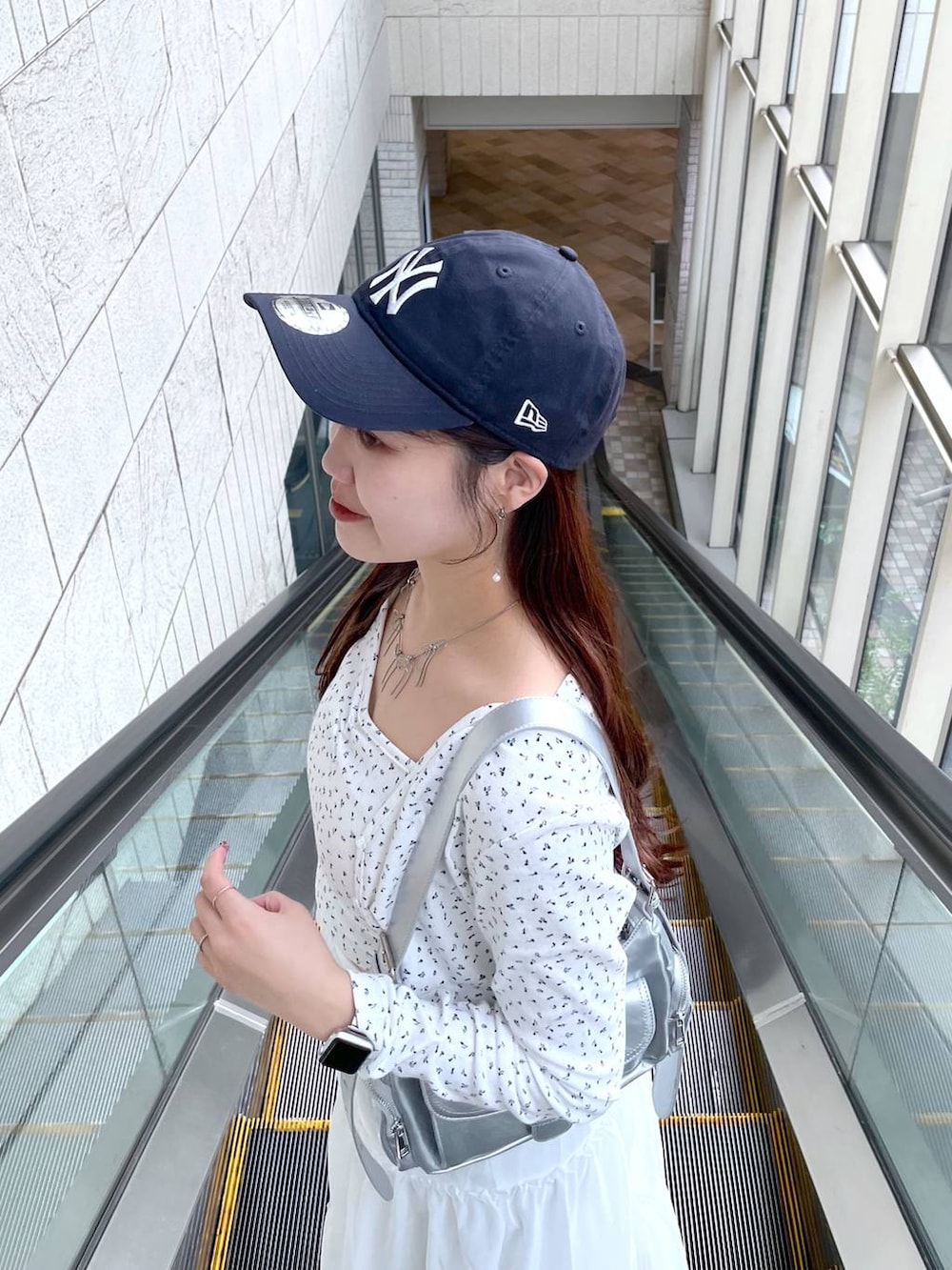 シルバー系のショルダーバッグ、ホワイト系のスカート、ホワイト系のアンサンブルを着用したレディースの春コーディネートの3枚目の写真