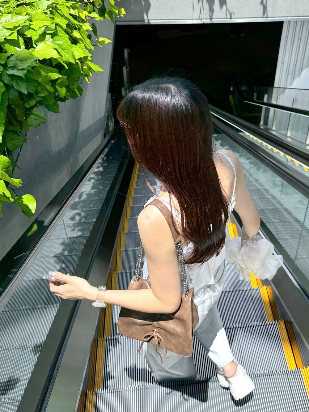 ホワイト系のキャミソール、グレー系のデニムパンツ、ホワイト系のサンダルを着用したレディースの夏コーディネートの9枚目の写真