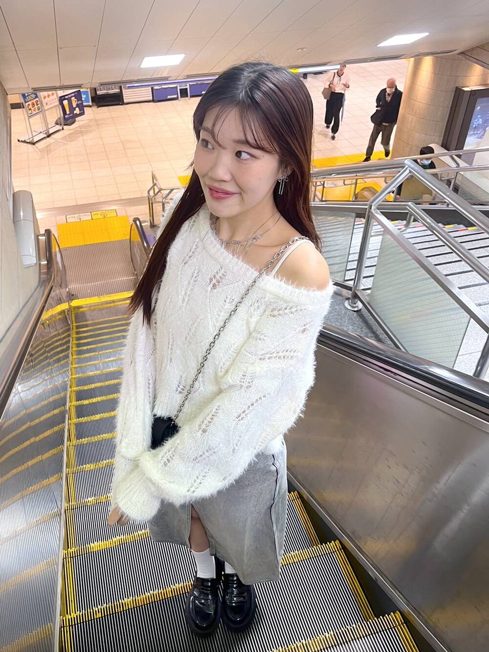 ブルー系のデニムスカート、ホワイト系のキャミソール、ブラック系のローファーを着用したレディースの秋コーディネートの5枚目の写真