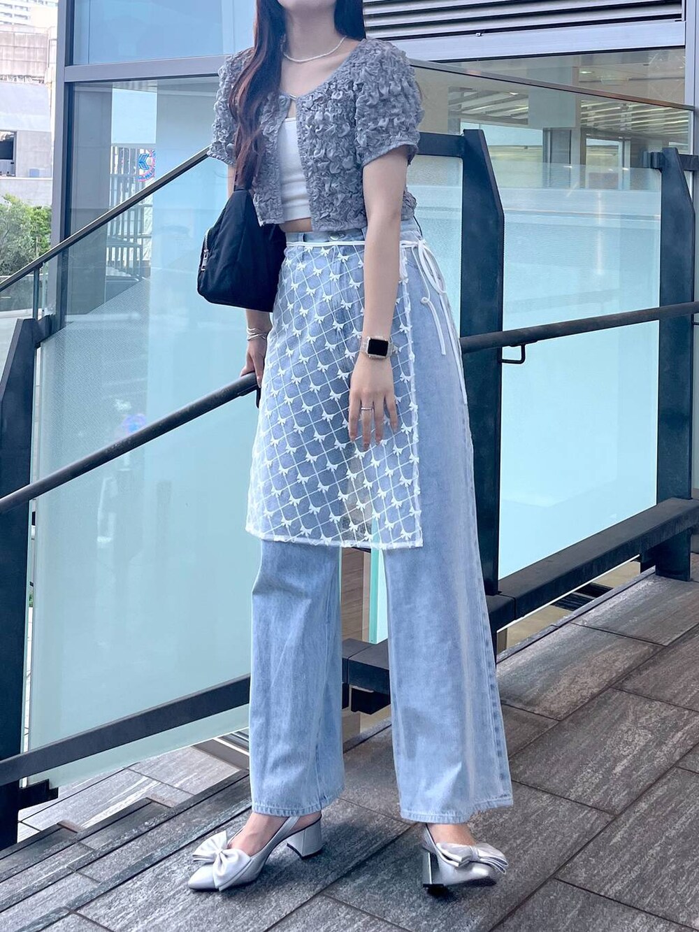 シルバー系のサンダル、ホワイト系のキャミソール、ブルー系のデニムパンツを着用したレディースの夏コーディネートの7枚目の写真