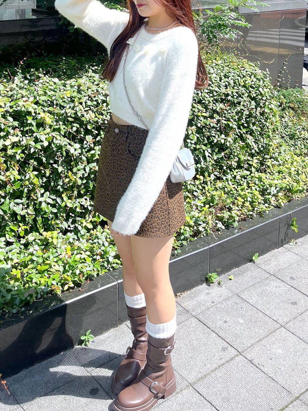 ブラウン系のブーツ、その他のスカート、シルバー系のショルダーバッグを着用したレディースの秋コーディネートの4枚目の写真