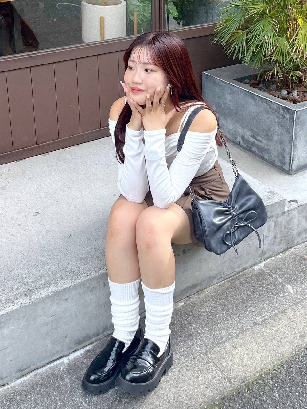 ブラウン系のスカート、グレー系のショルダーバッグ、ホワイト系のキャミソールを着用したレディースの秋コーディネートの8枚目の写真