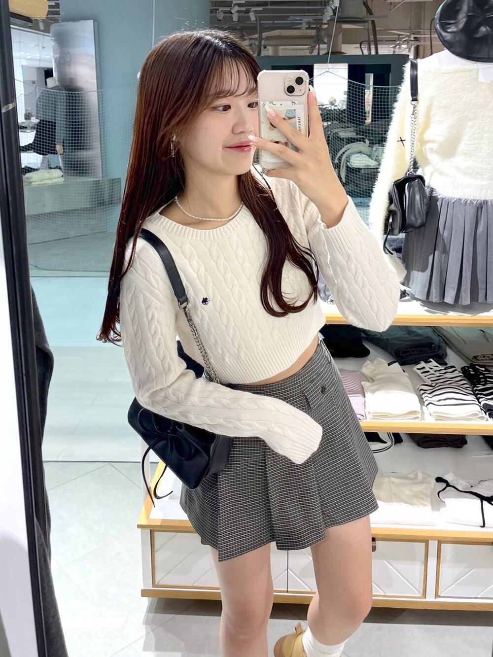 ホワイト系のニット/セーター、ブラック系のショルダーバッグ、ベージュ系のスカートを着用したレディースの秋コーディネートの7枚目の写真