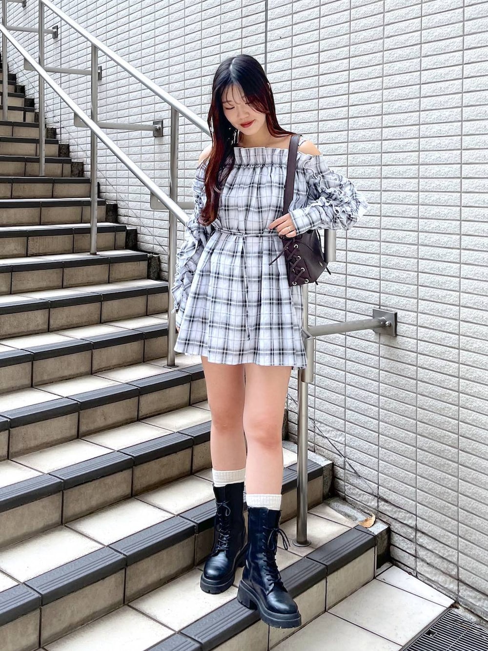 ホワイト系のキャミソール、ブラック系のデニムスカート、ブラウン系のショルダーバッグを着用したレディースの春コーディネートの4枚目の写真