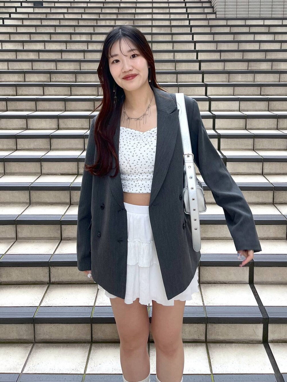 ホワイト系のキャミソール、ホワイト系のスカート、グレー系のテーラードジャケットを着用したレディースの春コーディネートの7枚目の写真