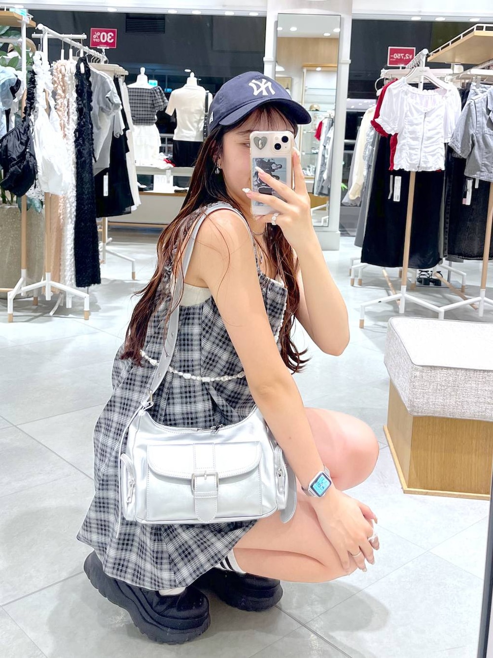 ブラック系のスニーカー、ホワイト系のキャミソール、シルバー系のショルダーバッグを着用したレディースの夏コーディネートの5枚目の写真