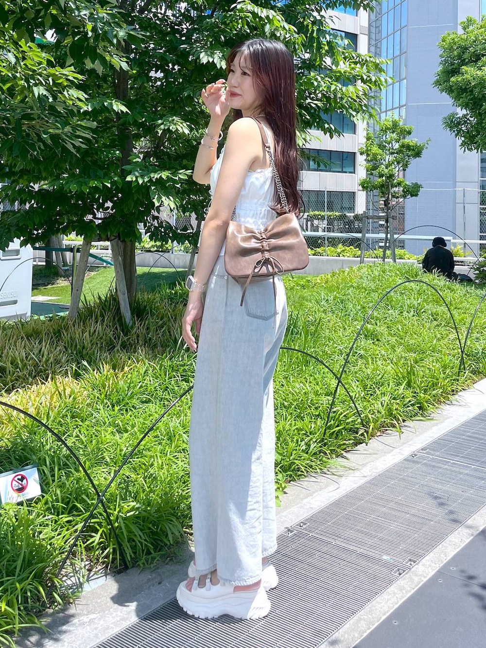 ホワイト系のキャミソール、グレー系のデニムパンツ、ホワイト系のサンダルを着用したレディースの夏コーディネートの2枚目の写真