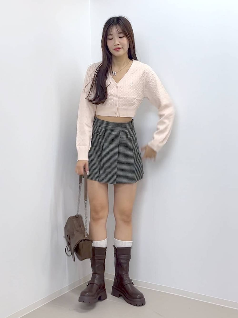 ブラウン系のショルダーバッグ、ブラウン系のブーツ、ホワイト系のキャミソールを着用したレディースの秋コーディネートの6枚目の写真