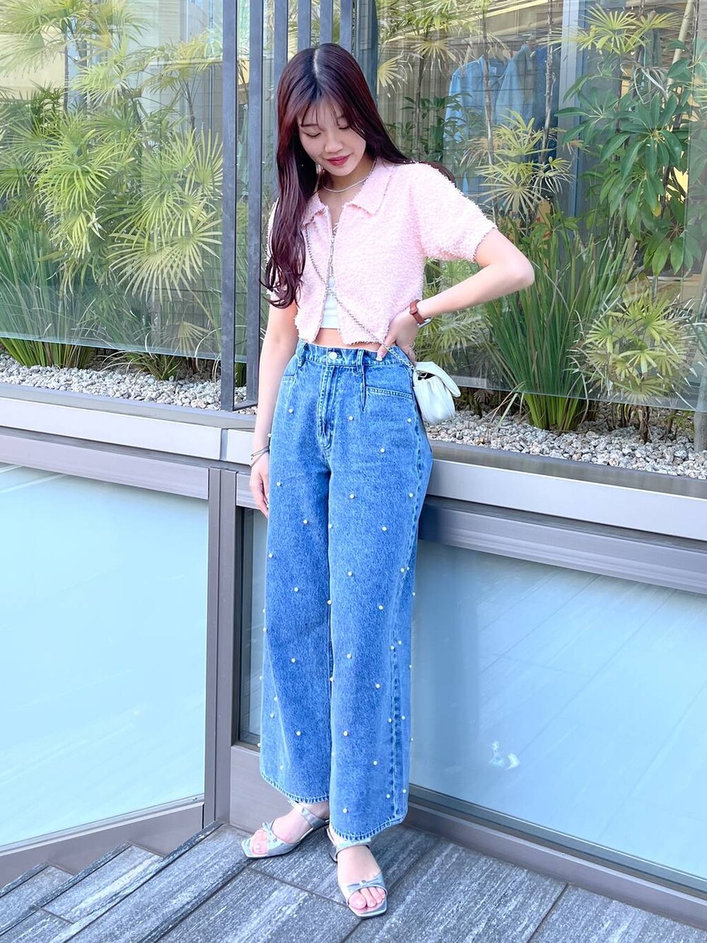 ホワイト系のショルダーバッグ、ホワイト系のキャミソール、ブルー系のデニムパンツを着用したレディースの春コーディネートの5枚目の写真