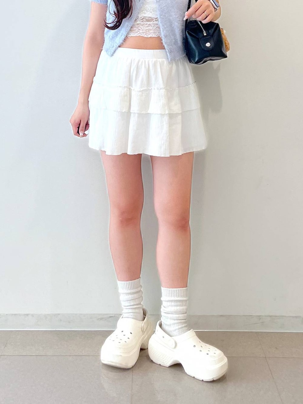 ホワイト系のスカート、ブラック系のボストンバッグ、ホワイト系のキャミソールを着用したレディースの春コーディネートの10枚目の写真