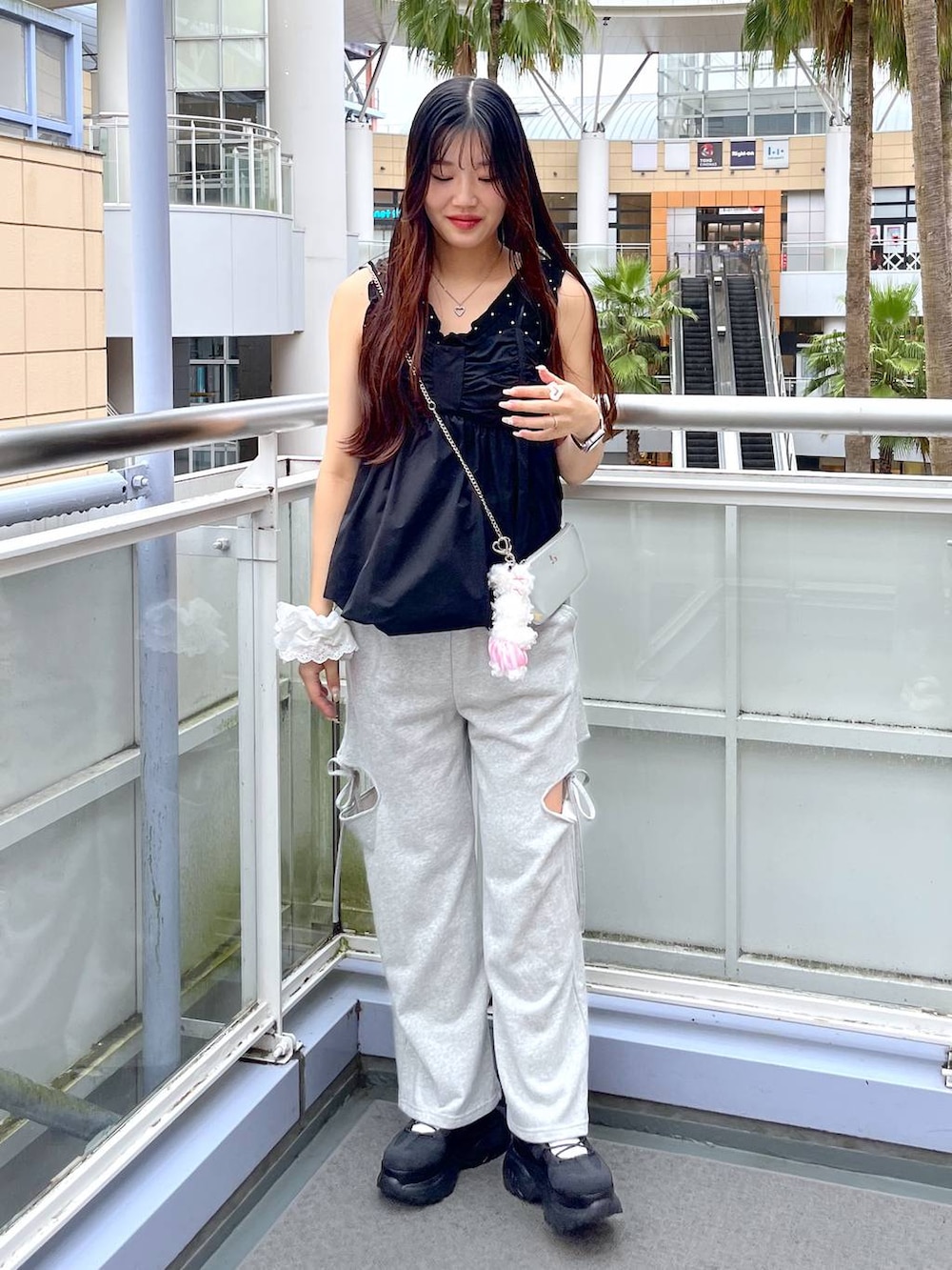 グレー系のスウェットパンツ、ブラック系のシャツ/ブラウス、シルバー系のショルダーバッグを着用したレディースの夏コーディネートの3枚目の写真