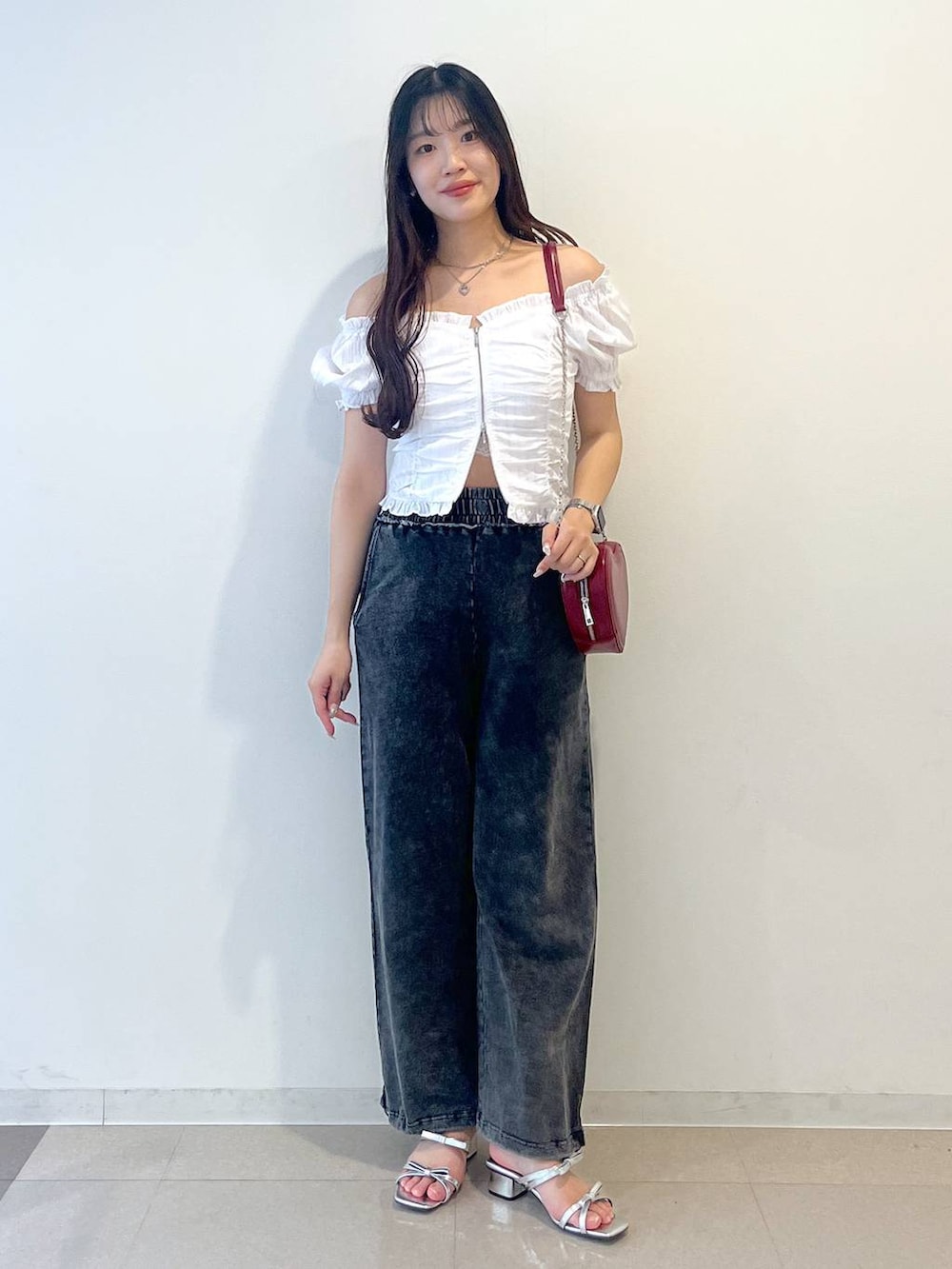 シルバー系のサンダル、レッド系のショルダーバッグ、ホワイト系のキャミソールを着用したレディースの夏コーディネートの2枚目の写真