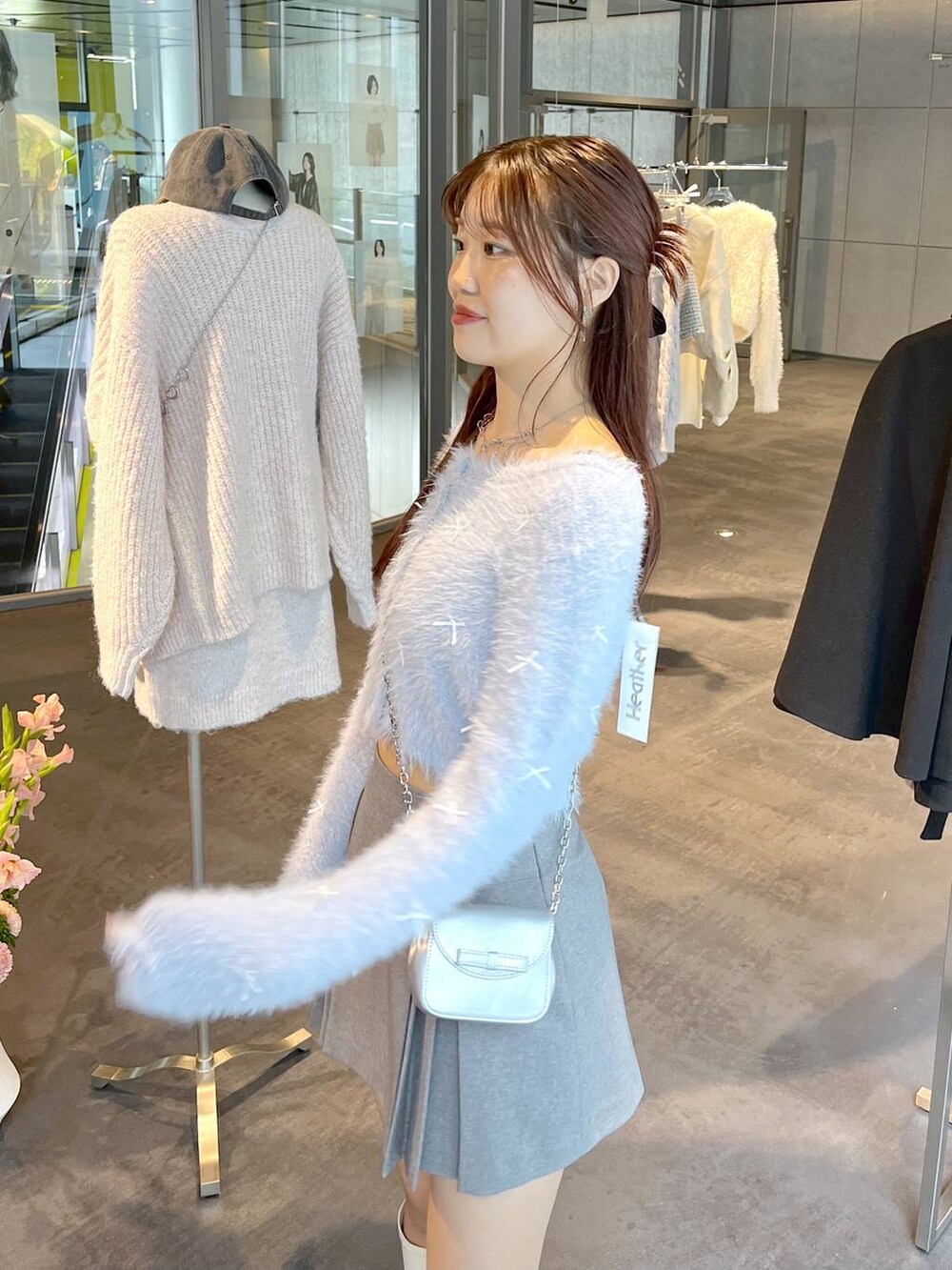 グレー系のスカート、ホワイト系のブーツ、ホワイト系のTシャツ/カットソーを着用したレディースの秋コーディネートの9枚目の写真