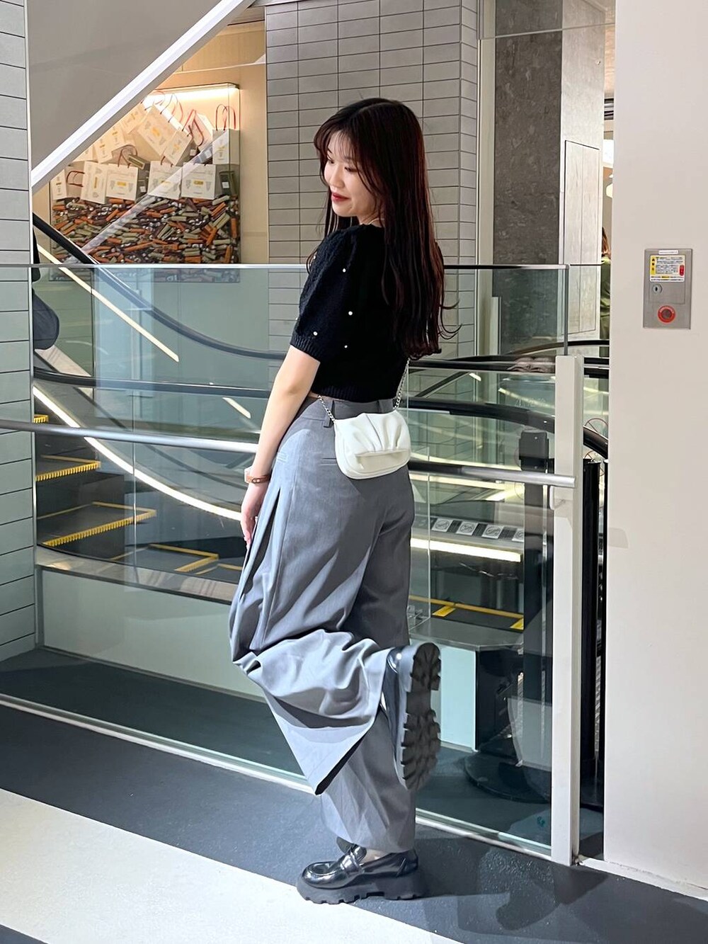 ホワイト系のショルダーバッグ、ホワイト系のキャミソール、ブラック系のローファーを着用したレディースの春コーディネートの4枚目の写真