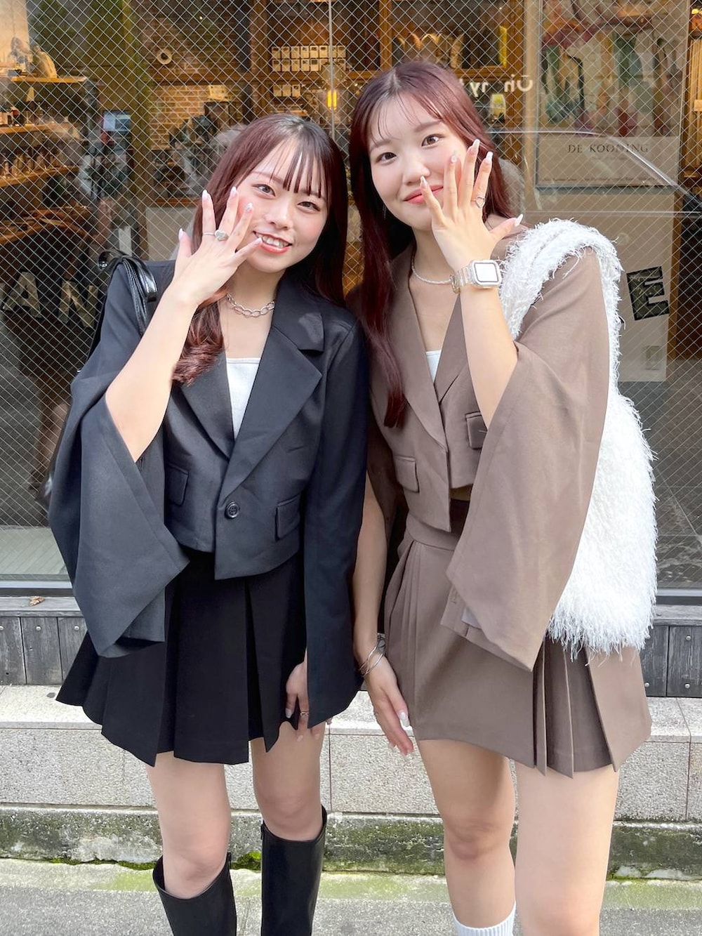 ブラック系のテーラードジャケット、ブラウン系のテーラードジャケット、ブラウン系のスカートを着用したレディースの冬コーディネートの3枚目の写真