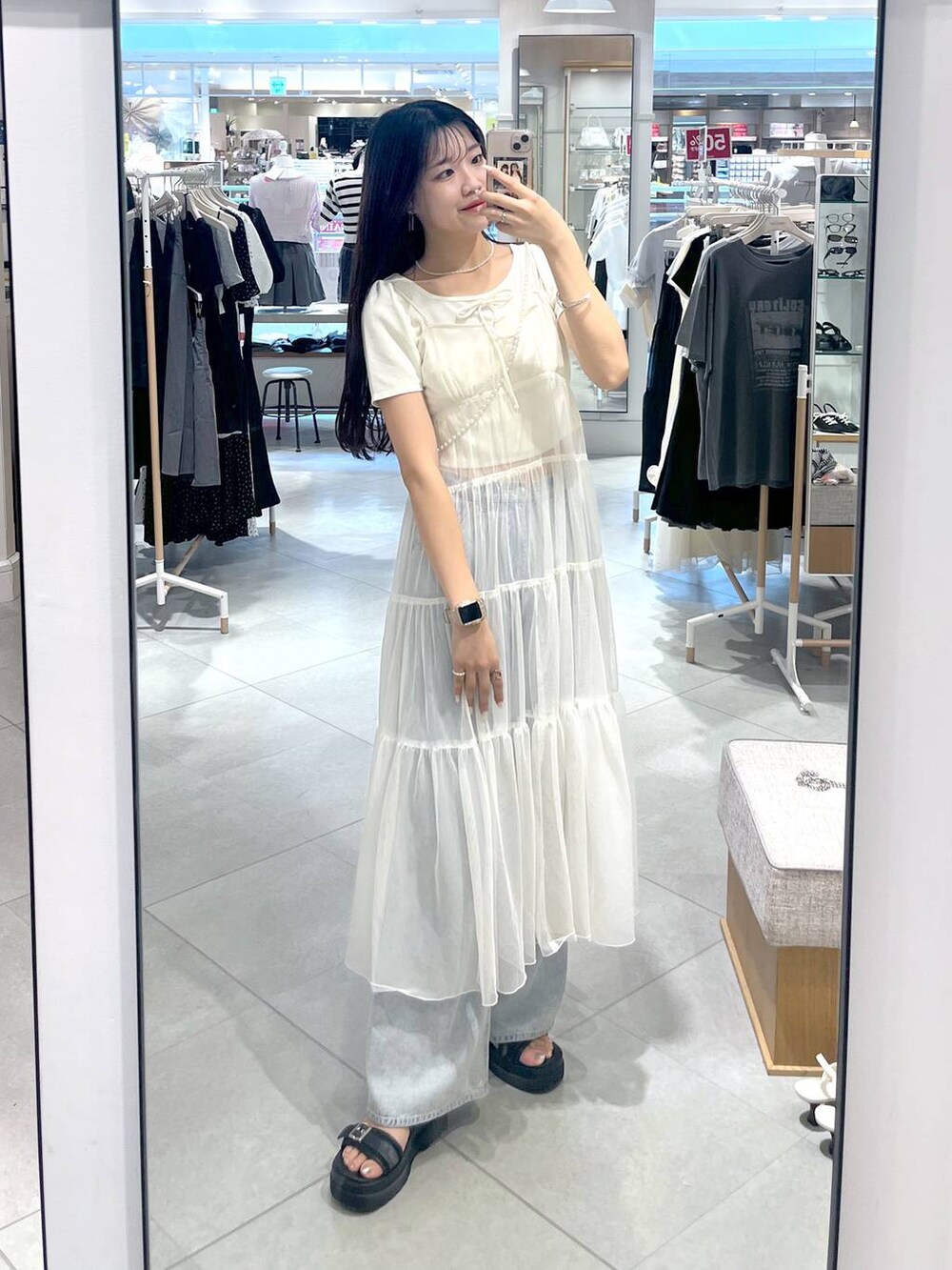 ホワイト系のワンピース、ホワイト系のキャミソール、ブルー系のデニムパンツを着用したレディースの夏コーディネートの9枚目の写真