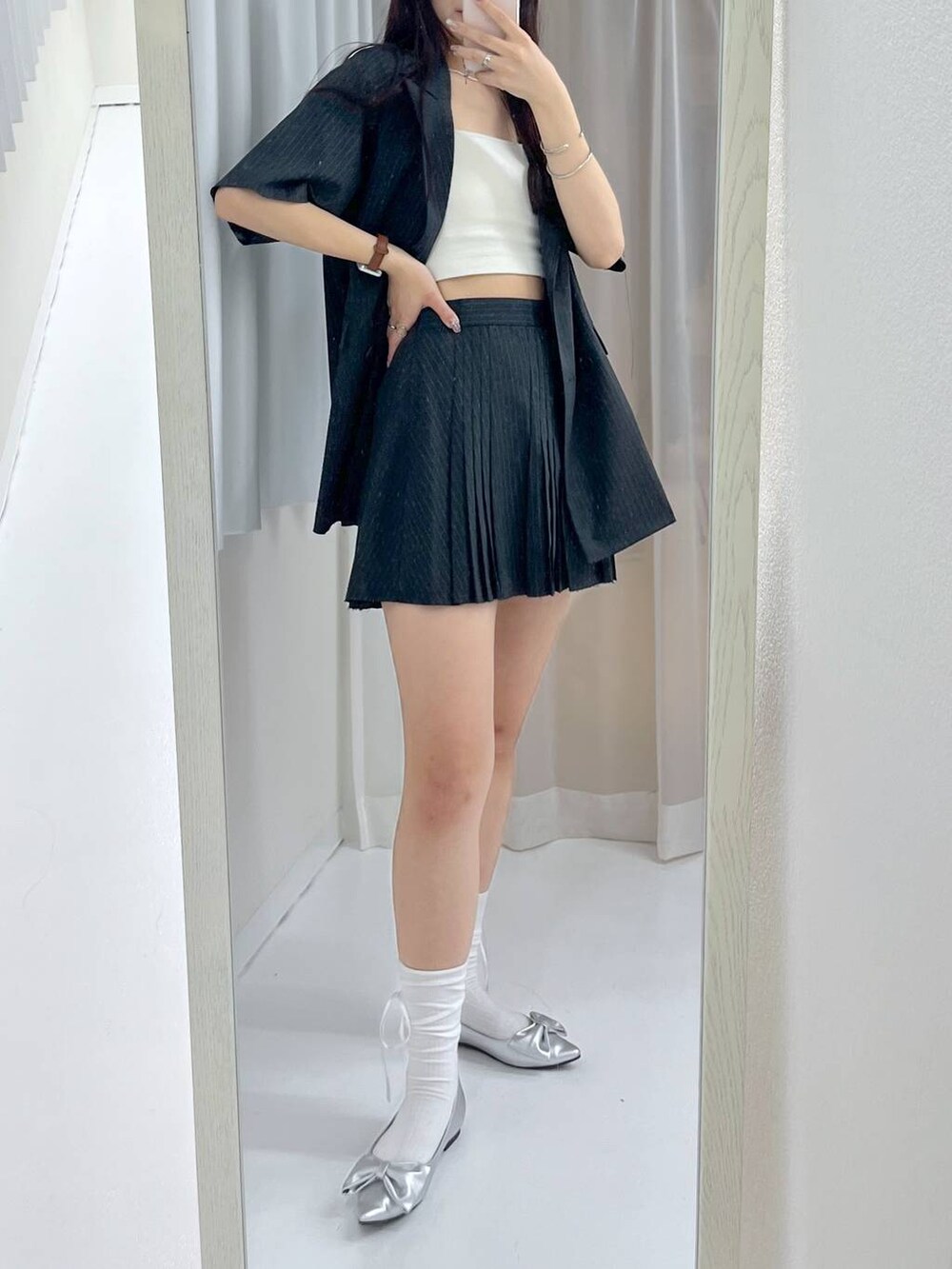 グレー系のスカート、ホワイト系のキャミソール、シルバー系のパンプスを着用したレディースの春コーディネートの4枚目の写真