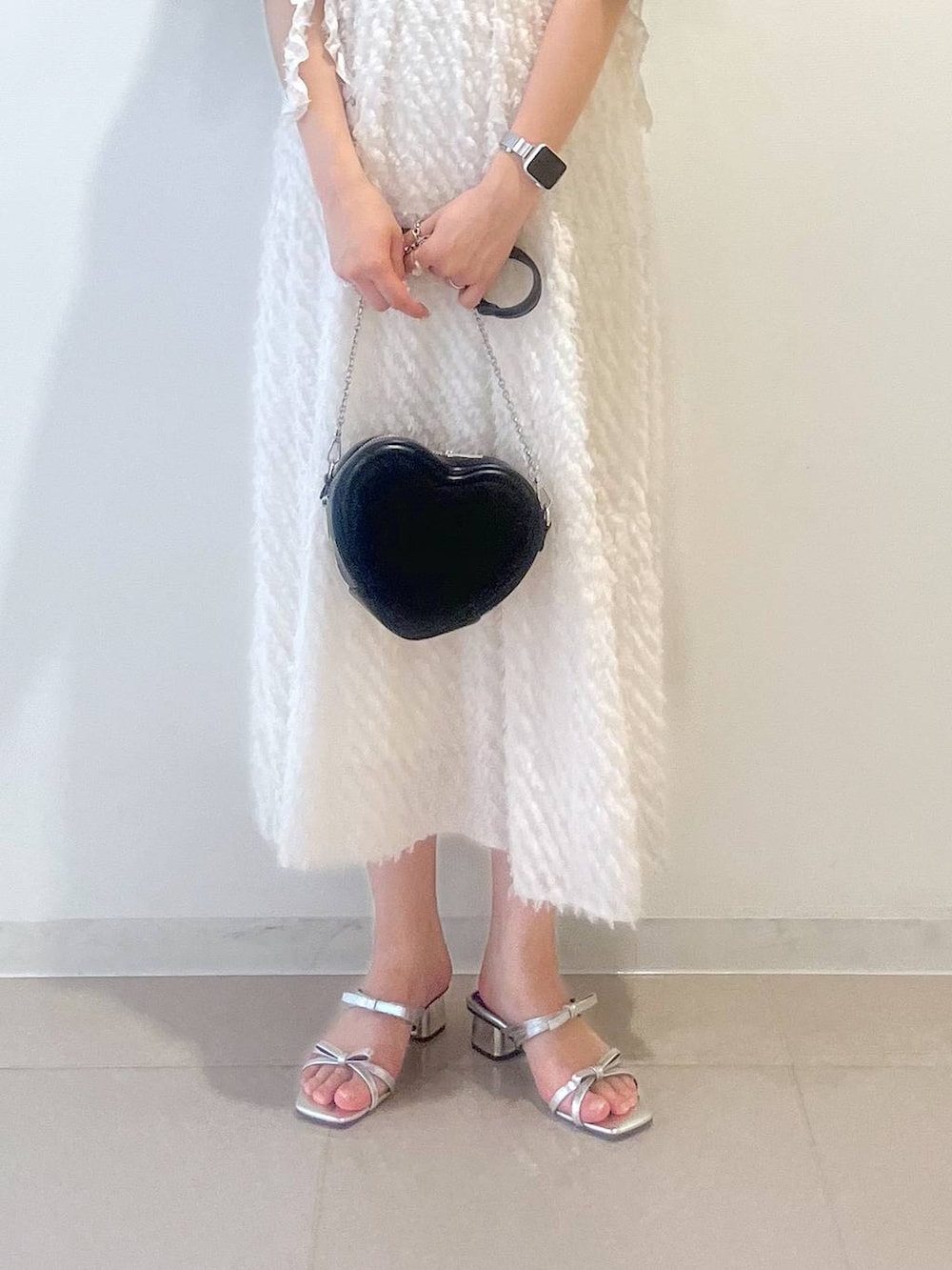 シルバー系のサンダル、ホワイト系のワンピース、ブラック系のショルダーバッグを着用したレディースの春コーディネートの9枚目の写真