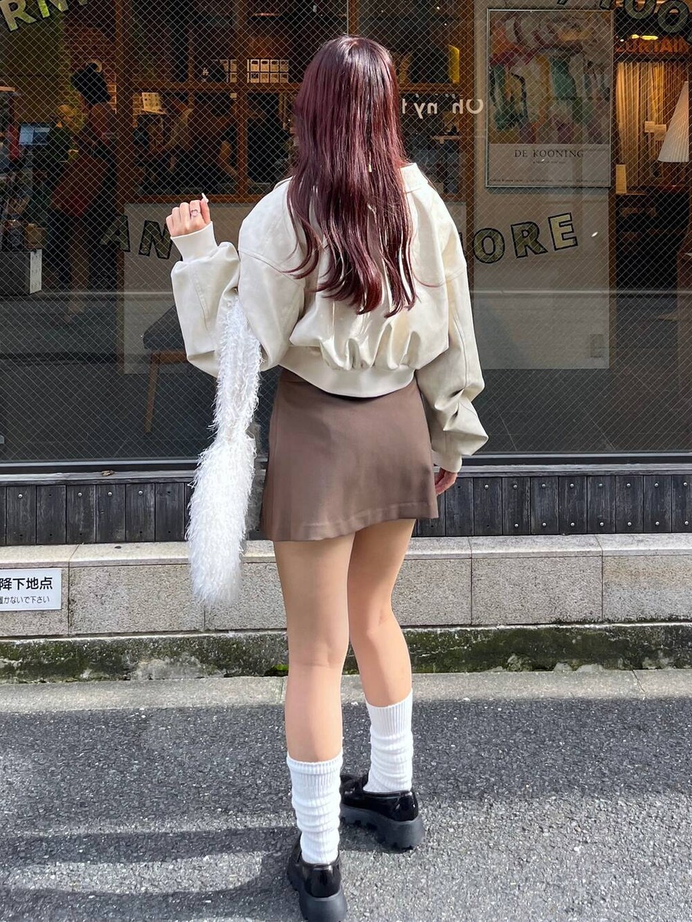 ブラウン系のスカート、ホワイト系のショルダーバッグ、ブラック系のローファーを着用したレディースの秋コーディネートの5枚目の写真