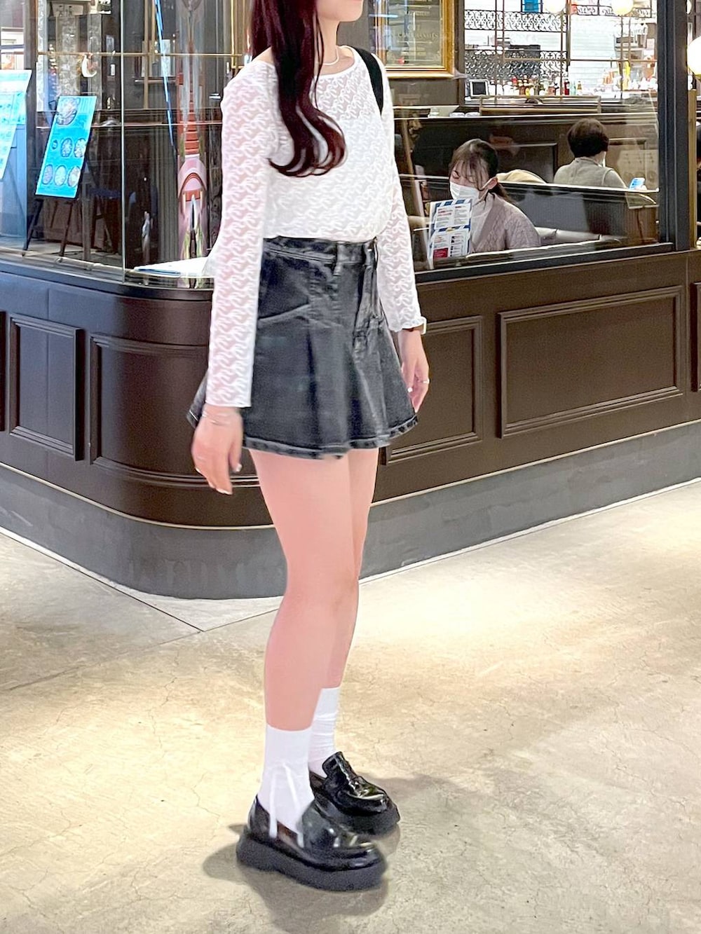 ブラック系のショルダーバッグ、ブラック系のローファー、ブラック系のデニムスカートを着用したレディースの春コーディネートの5枚目の写真