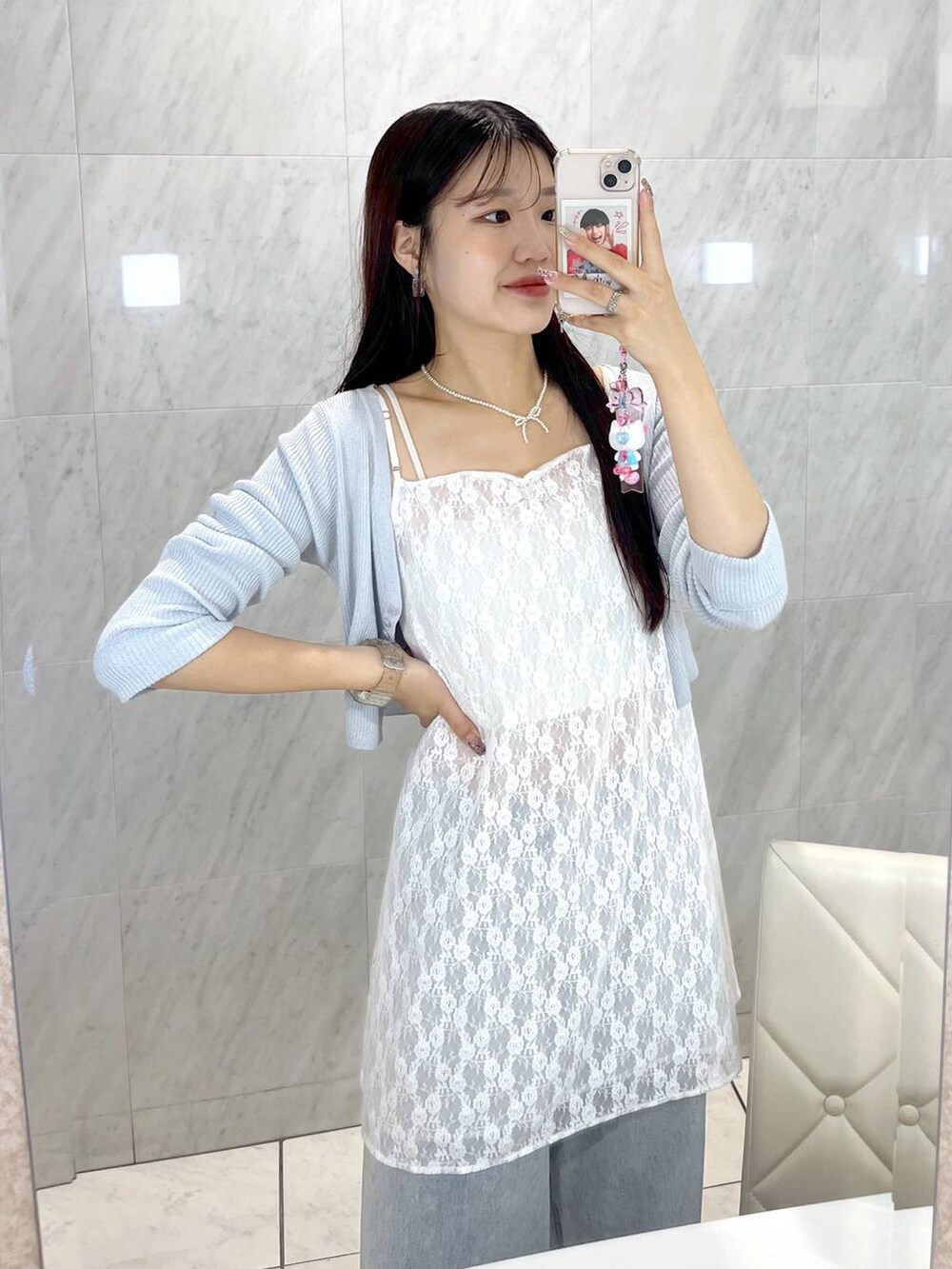 シルバー系のサンダル、ブルー系のカーディガン/ボレロ、ホワイト系のキャミソールを着用したレディースの春コーディネートの3枚目の写真