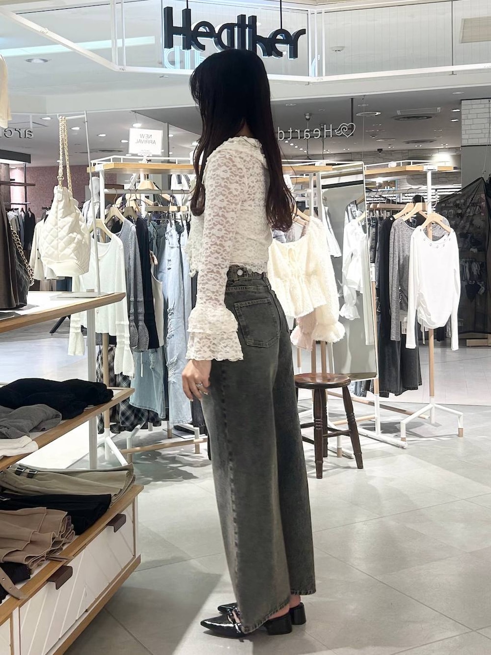 ホワイト系のキャミソール、ブルー系のデニムパンツ、ブラウン系のボストンバッグを着用したレディースの春コーディネートの5枚目の写真
