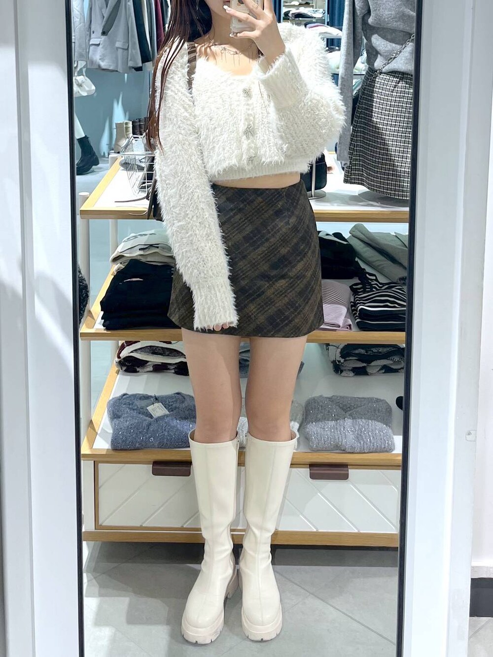 ブラウン系のショルダーバッグ、ホワイト系のブーツ、ホワイト系のキャミソールを着用したレディースの秋コーディネートの3枚目の写真