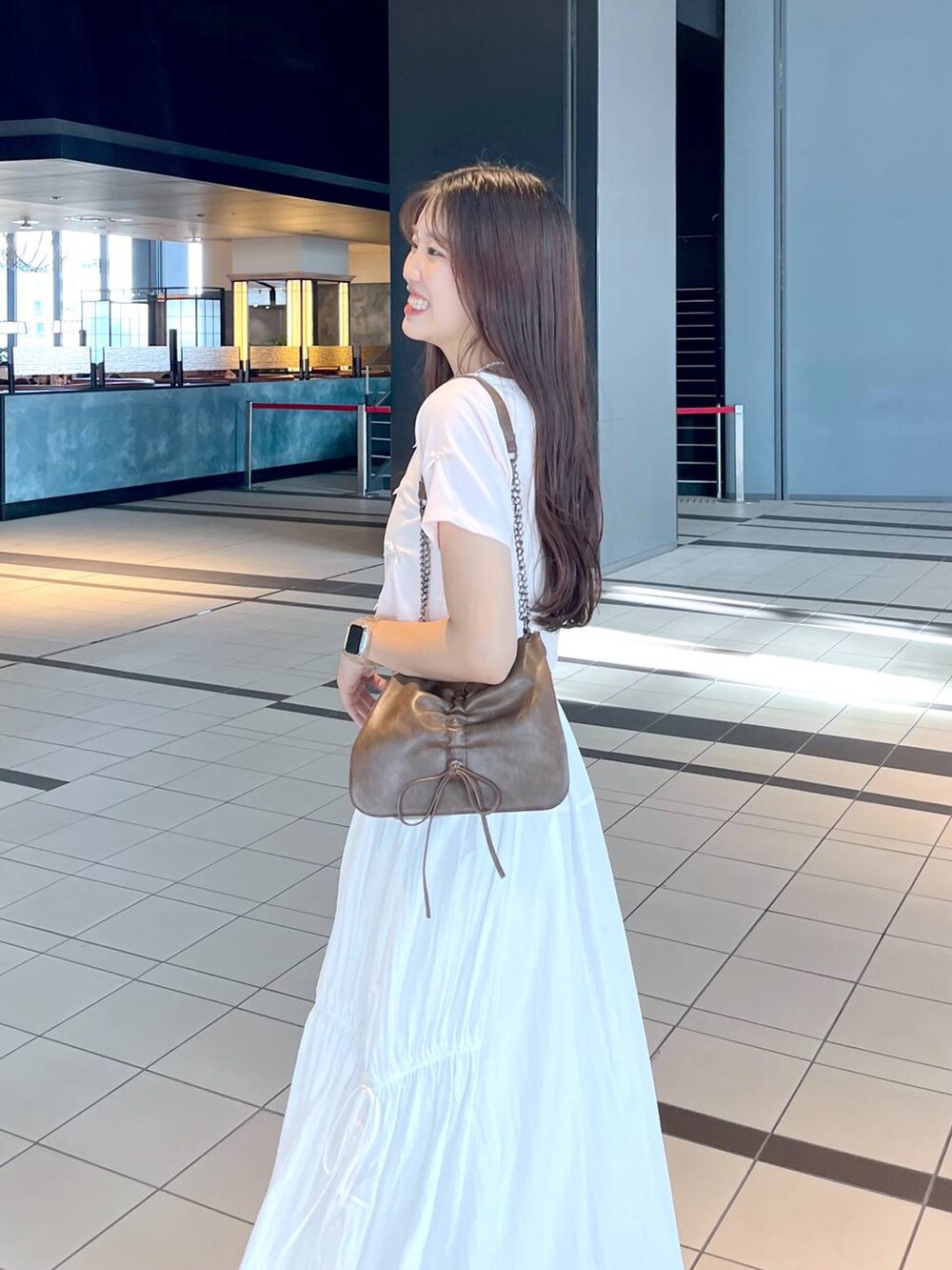 ピンク系のTシャツ/カットソー、ホワイト系のキャミソール、ブラウン系のショルダーバッグを着用したレディースの夏コーディネートの7枚目の写真