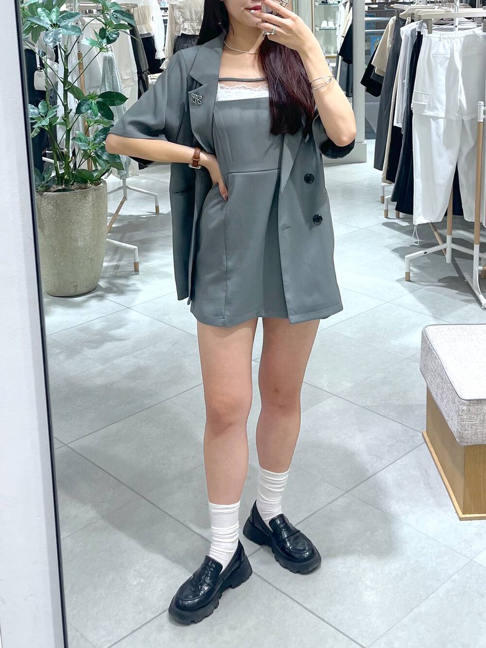 グレー系のワンピース、ブラック系のローファー、ホワイト系のキャミソールを着用したレディースの春コーディネートの3枚目の写真