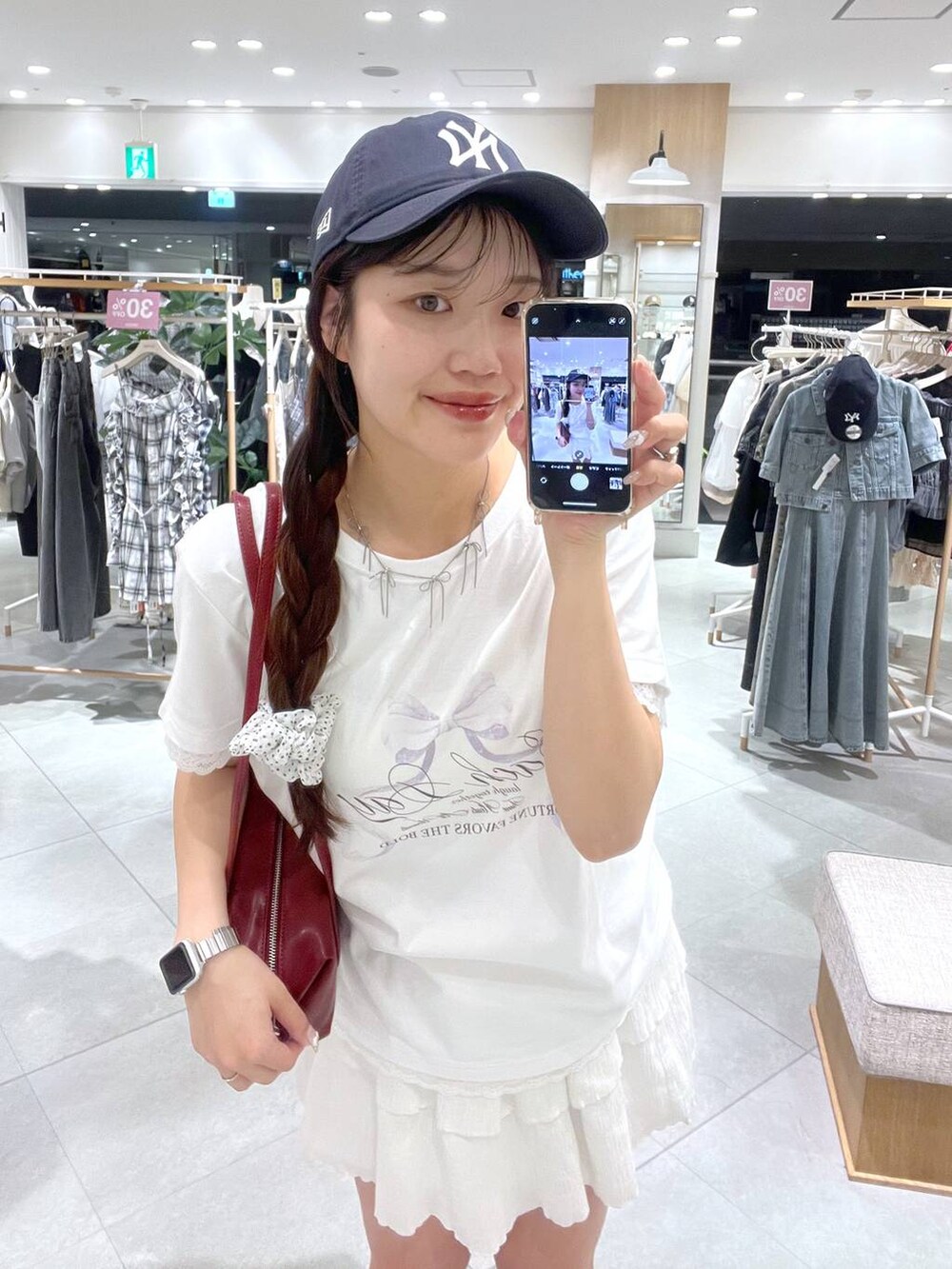 ホワイト系のキャミソール、ホワイト系のスカート、レッド系のボストンバッグを着用したレディースの春コーディネートの5枚目の写真