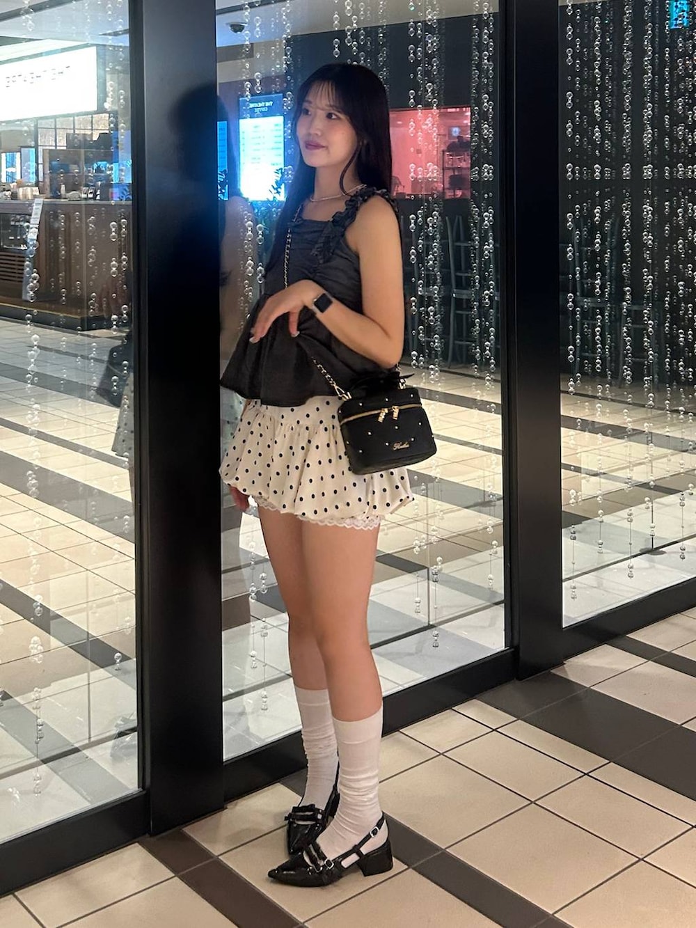 グレー系のキャミソール、ブラック系のショルダーバッグ、その他のスカートを着用したレディースの夏コーディネートの2枚目の写真