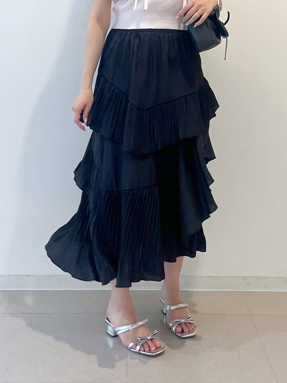 グレー系のショルダーバッグ、ホワイト系のキャミソール、ブラック系のスカートを着用したレディースの春コーディネートの8枚目の写真